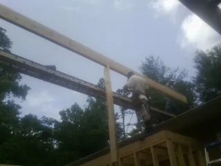 Carpenter setting a ridge beam over a new addition frame — Ice Dam Removal by Roofing Brothers in South Bethlehem