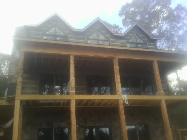 Dormers and porch framing on a large log home under construction — Roof Coating work by our crew in South Bethlehem