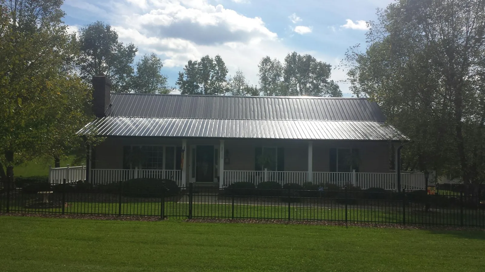 Gray metal roof on a brick ranch with a full width front porch — Gutter Guard Installation work by our crew in South Bethlehem