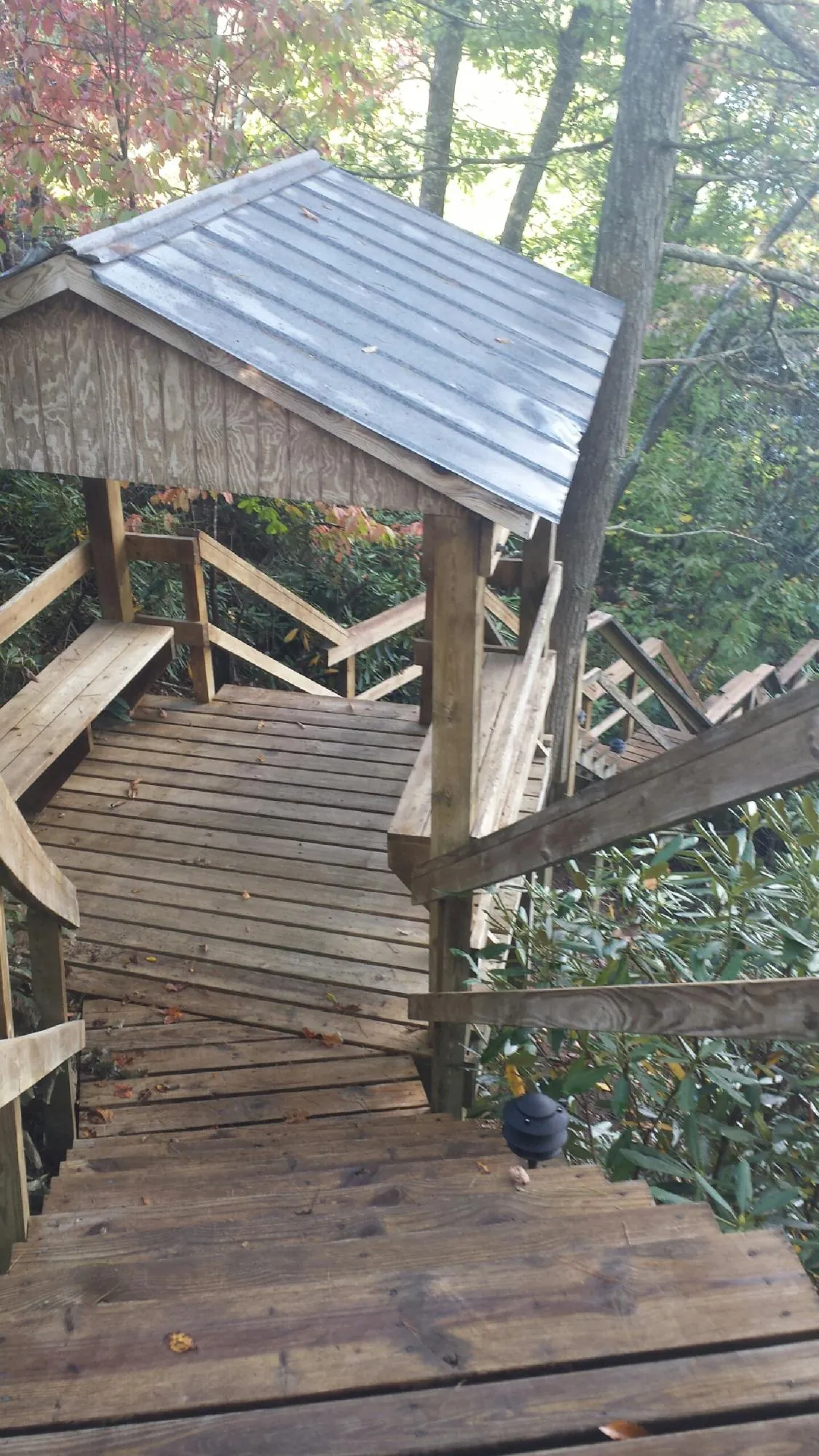 Metal roofed shelter over wooden steps on a wooded walkway — Skylight Repair & Installation work by our crew in South Bethlehem
